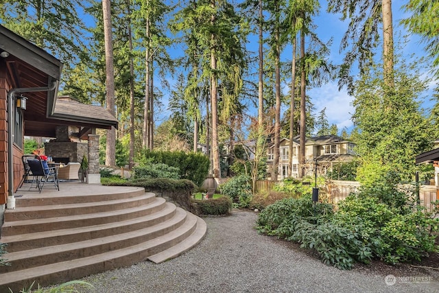 view of yard with an outdoor fireplace and a patio area