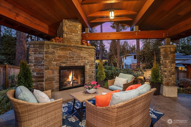 patio terrace at dusk with an outdoor stone fireplace