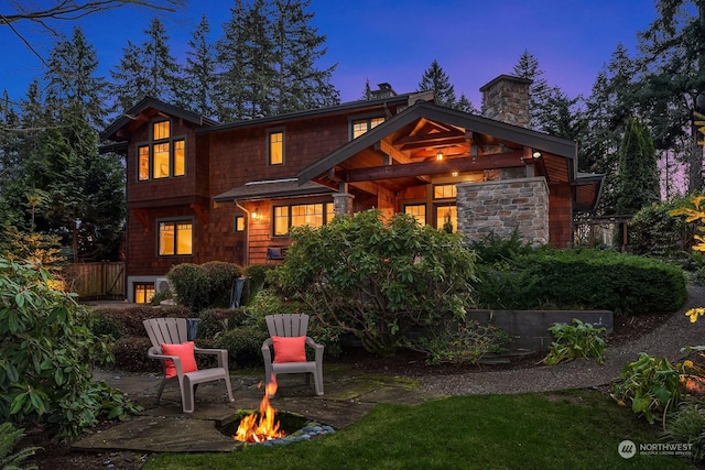 back house at dusk featuring an outdoor fire pit and a patio