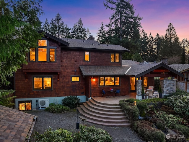 back house at dusk featuring ac unit and a patio area