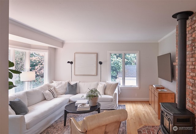 living room featuring light wood-type flooring, crown molding, and a wood stove