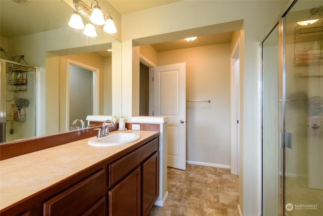 bathroom featuring walk in shower, a notable chandelier, and vanity