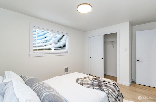 bedroom with light hardwood / wood-style flooring and a closet