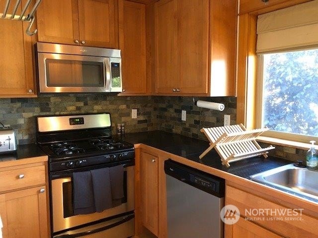 kitchen with tasteful backsplash, stainless steel appliances, and sink