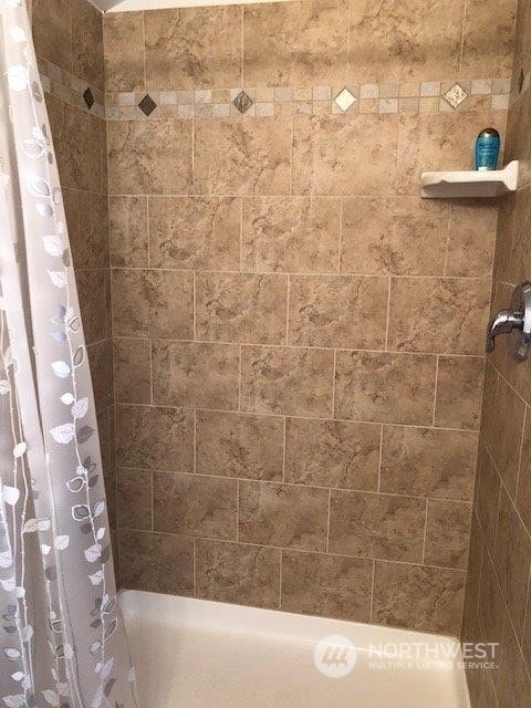 bathroom with shower / bath combo with shower curtain