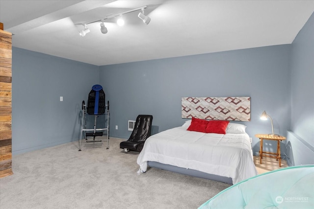 bedroom with light carpet and rail lighting