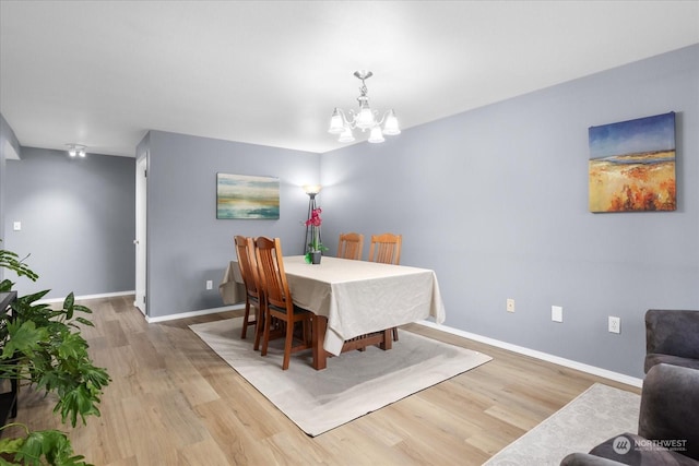 dining room with an inviting chandelier and light hardwood / wood-style flooring