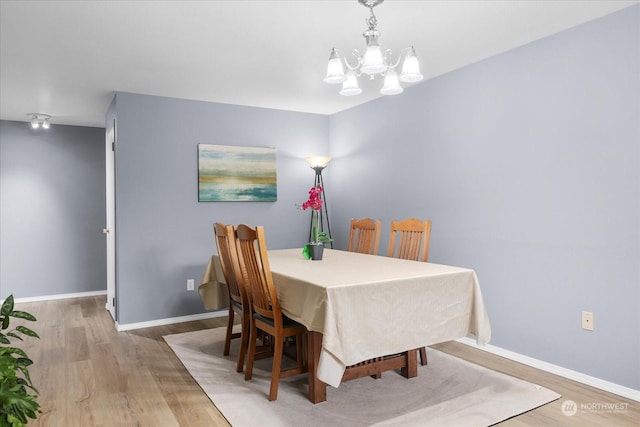 dining area with a chandelier and light wood-type flooring