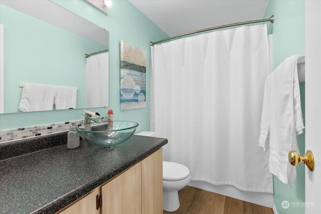 full bathroom featuring shower / bathtub combination with curtain, hardwood / wood-style flooring, vanity, decorative backsplash, and toilet