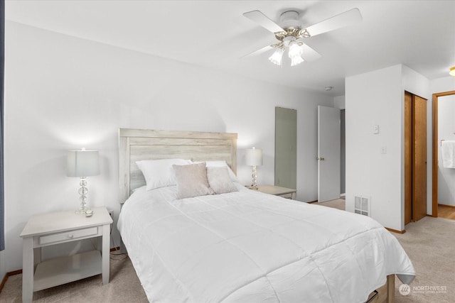 carpeted bedroom with ceiling fan and a closet