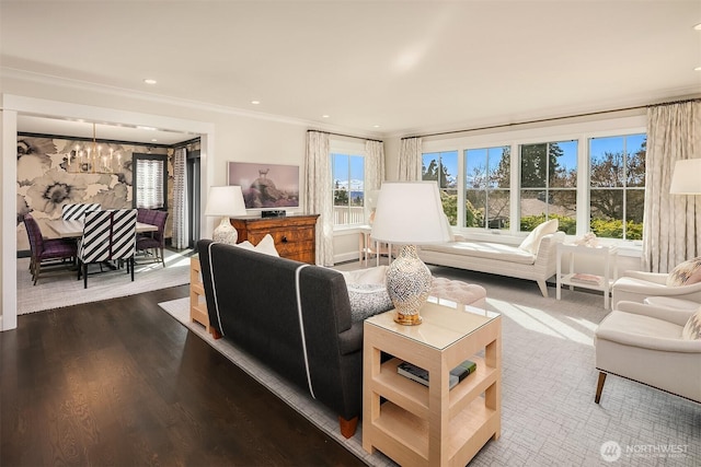 living area with dark wood finished floors, recessed lighting, crown molding, and an inviting chandelier