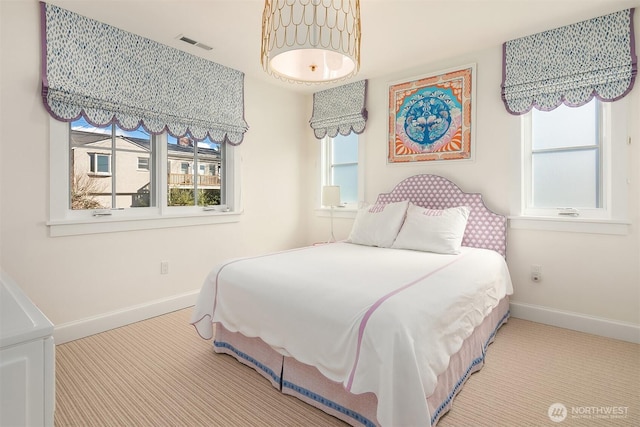 bedroom featuring carpet, multiple windows, baseboards, and visible vents