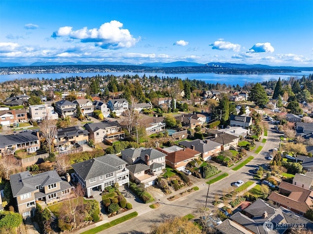 drone / aerial view featuring a residential view and a water and mountain view