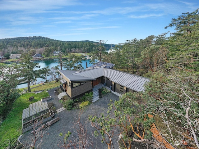 aerial view with a water view and a wooded view