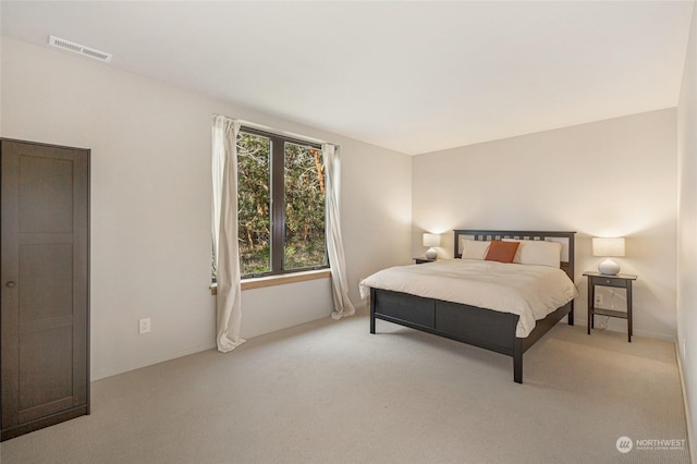 carpeted bedroom featuring visible vents and baseboards