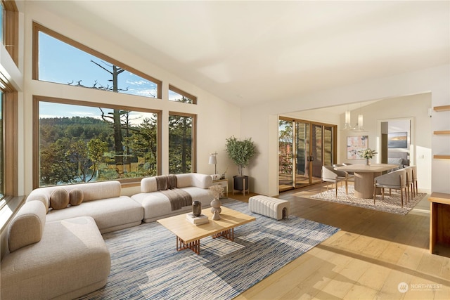 living area with high vaulted ceiling and wood finished floors