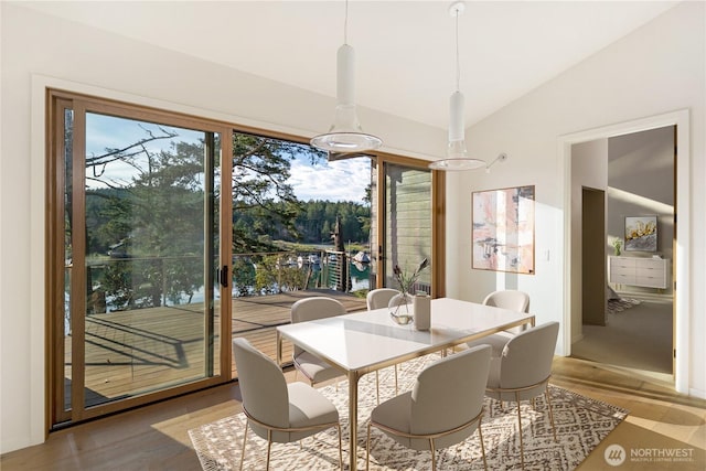 dining space featuring lofted ceiling and light wood-style flooring