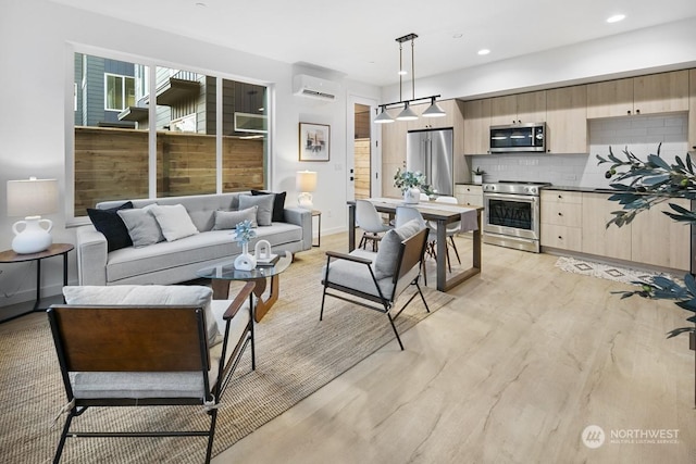 living room featuring light hardwood / wood-style flooring and a wall unit AC