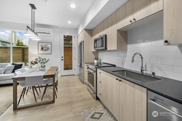 kitchen with sink, hanging light fixtures, appliances with stainless steel finishes, and light brown cabinets