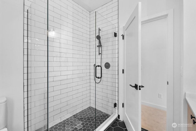 bathroom with toilet, tile patterned flooring, and a shower with shower door