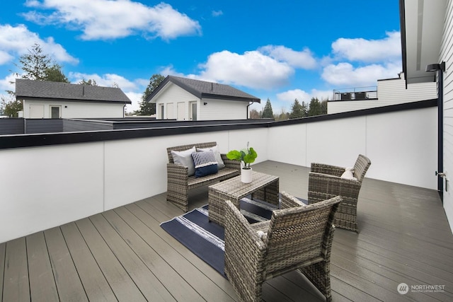 wooden terrace with an outdoor living space