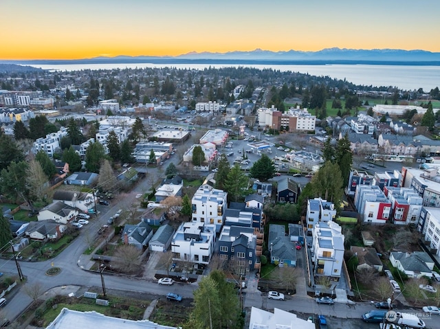 aerial view at dusk featuring a water view