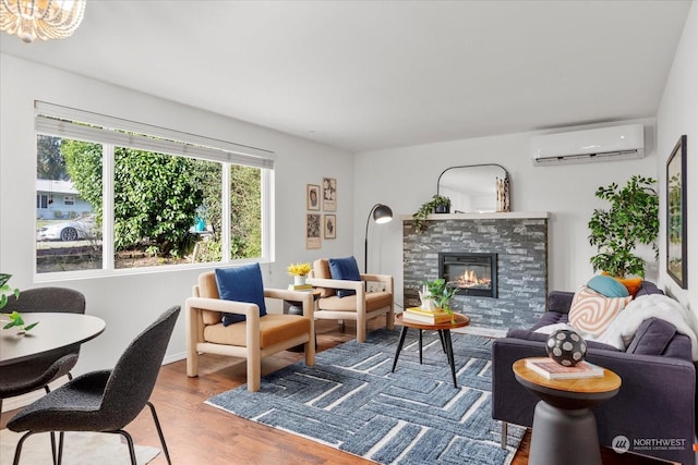 living room featuring hardwood / wood-style flooring, a stone fireplace, and a wall mounted air conditioner