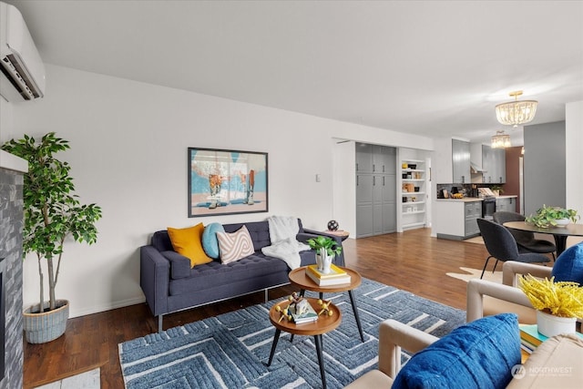 living room featuring an AC wall unit, an inviting chandelier, and dark hardwood / wood-style flooring