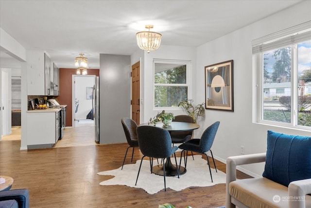 dining room featuring plenty of natural light, light hardwood / wood-style flooring, and an inviting chandelier