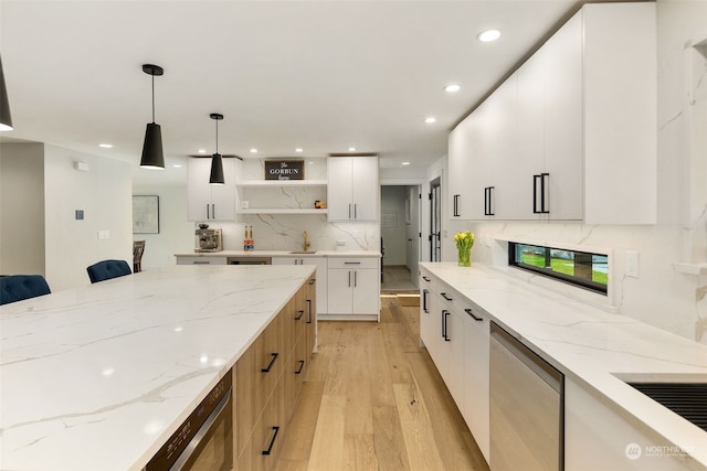 kitchen with white cabinetry, light hardwood / wood-style floors, decorative backsplash, light stone countertops, and pendant lighting