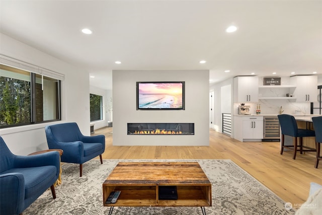 living room featuring light hardwood / wood-style flooring, indoor bar, and wine cooler