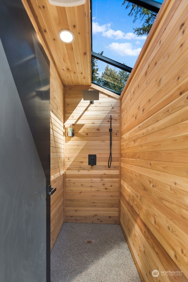 interior space featuring carpet floors, a skylight, wood walls, and wooden ceiling