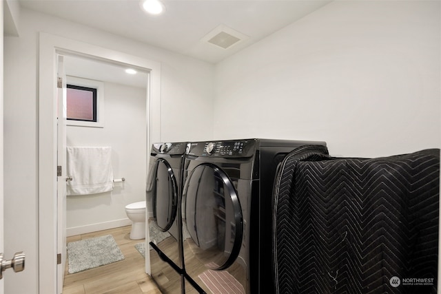 washroom featuring light hardwood / wood-style flooring and washing machine and clothes dryer