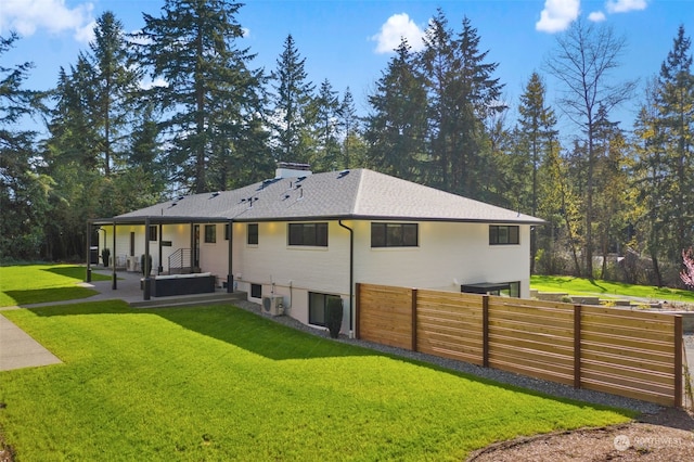 back of house with central air condition unit and a yard