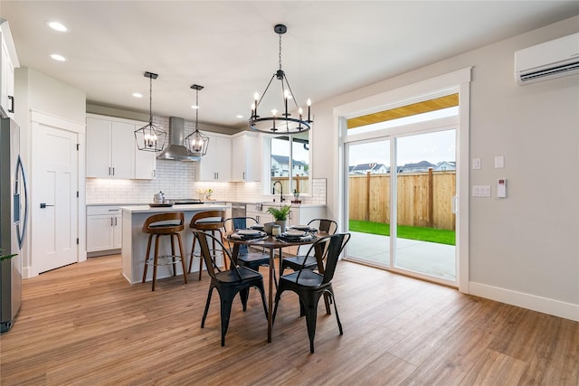 5986 Ranch Loop, Ferndale, WA 98248 - dining space featuring an AC wall unit, a chandelier, light wood-style flooring, recessed lighting, and baseboards