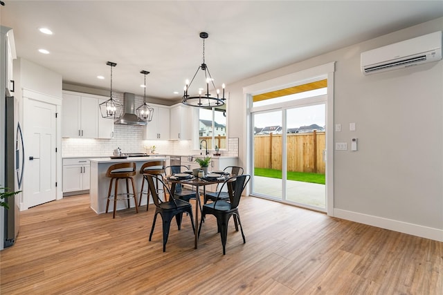 5986 Ranch Loop, Ferndale, WA 98248 - dining room featuring an AC wall unit, a chandelier, light wood-style flooring, recessed lighting, and baseboards