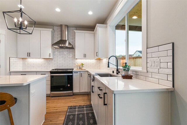 5986 Ranch Loop, Ferndale, WA 98248 - kitchen featuring stainless steel range oven, wall chimney range hood, a sink, tasteful backsplash, and a chandelier