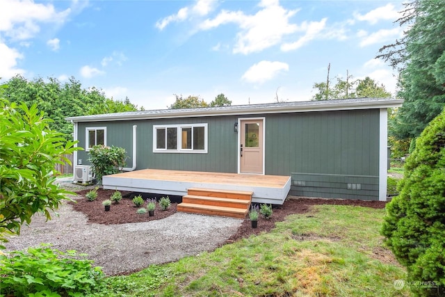 manufactured / mobile home featuring a deck, ac unit, and a front yard