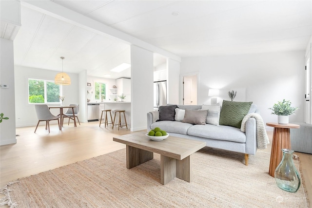 living room featuring light hardwood / wood-style flooring and lofted ceiling with beams