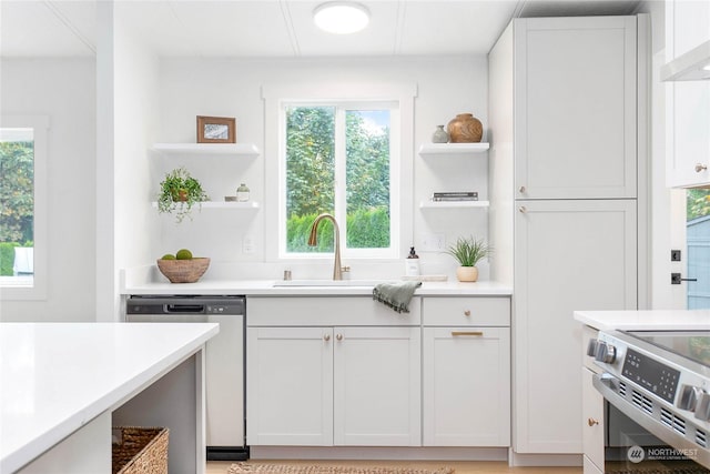 kitchen featuring appliances with stainless steel finishes, wall chimney exhaust hood, and white cabinets