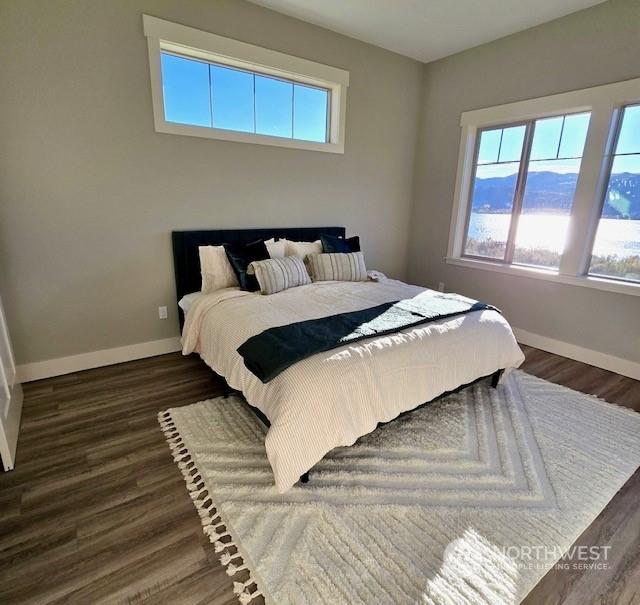 bedroom featuring dark wood-style floors and baseboards