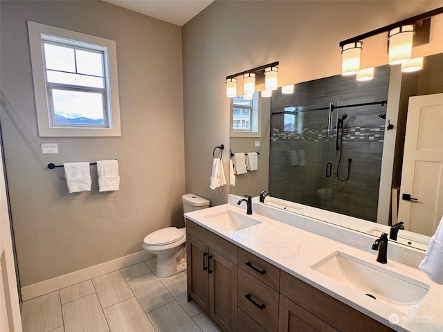 full bath featuring a stall shower, a sink, toilet, and baseboards