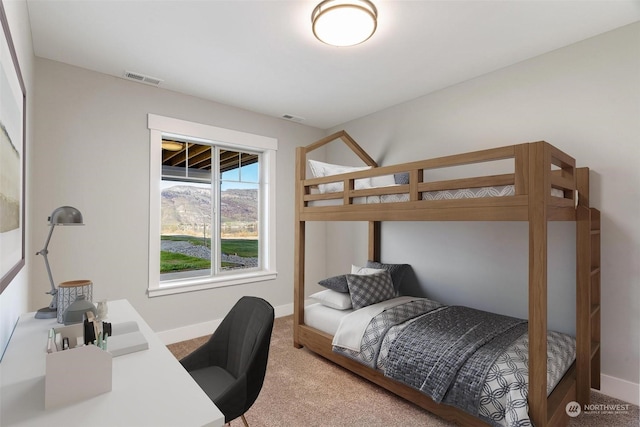 carpeted bedroom featuring visible vents and baseboards