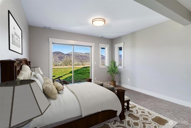 carpeted bedroom with access to exterior, visible vents, a mountain view, and baseboards