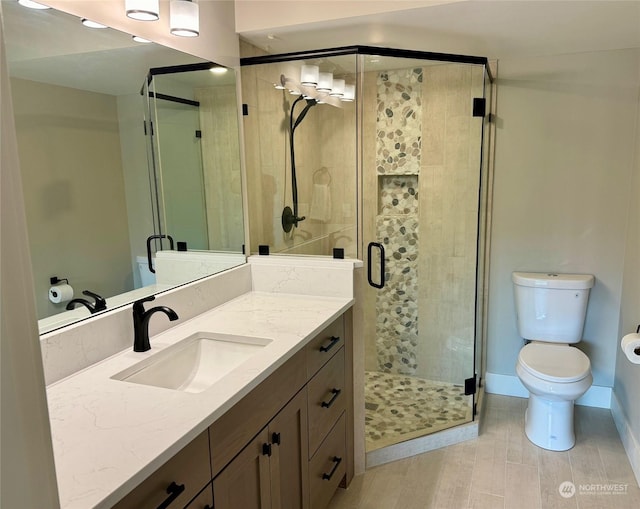 full bath with toilet, a shower stall, and vanity