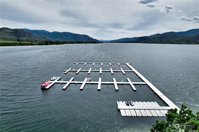 view of dock with a water and mountain view