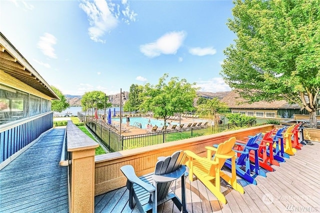 deck with fence, a community pool, and a mountain view