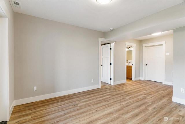 unfurnished room with light wood finished floors, baseboards, and visible vents