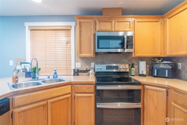 kitchen with sink, backsplash, and appliances with stainless steel finishes