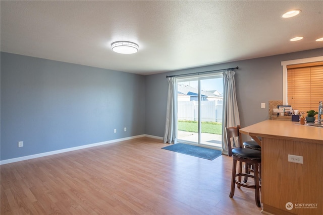 interior space with sink, a textured ceiling, and light wood-type flooring